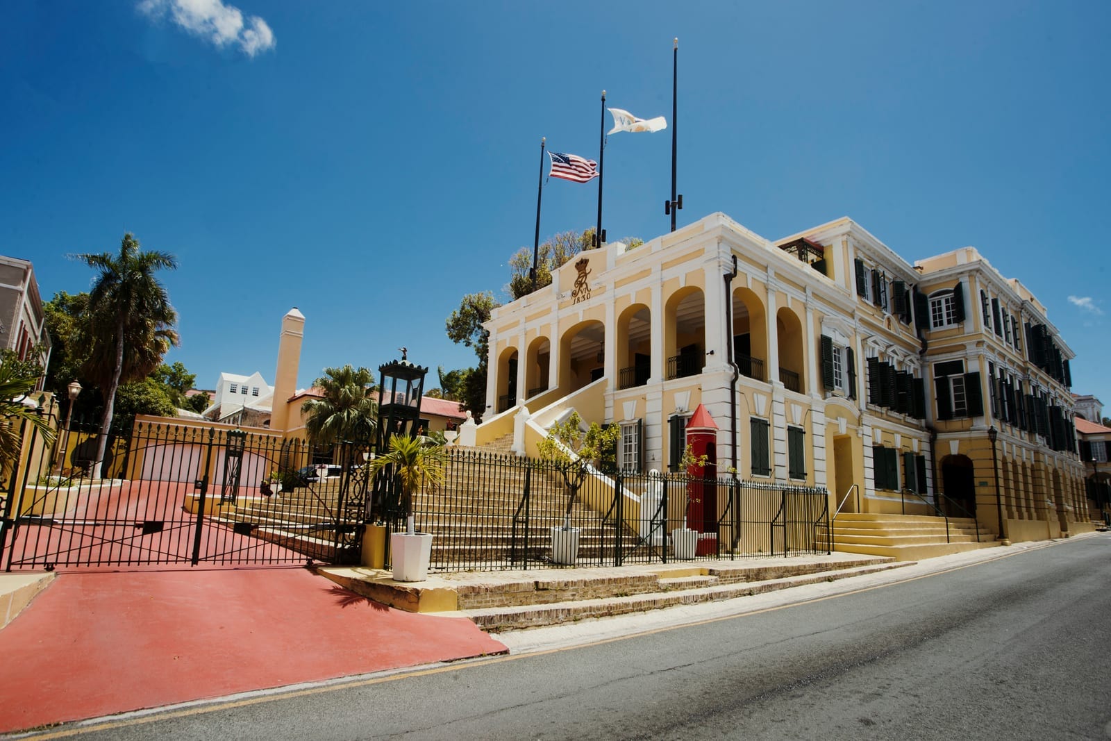 Government House in Christiansted, St. Croix, with American and Virgin Islands flags flying under bright sun